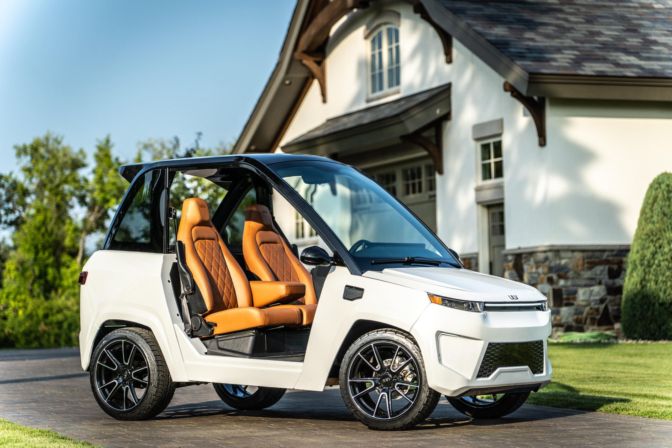 white ulv 322 parked in a driveway beside a large house